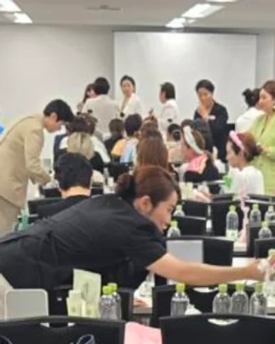 蛍光灯の貸し会議室。前に立って教える人たちと、座った大勢の参加者